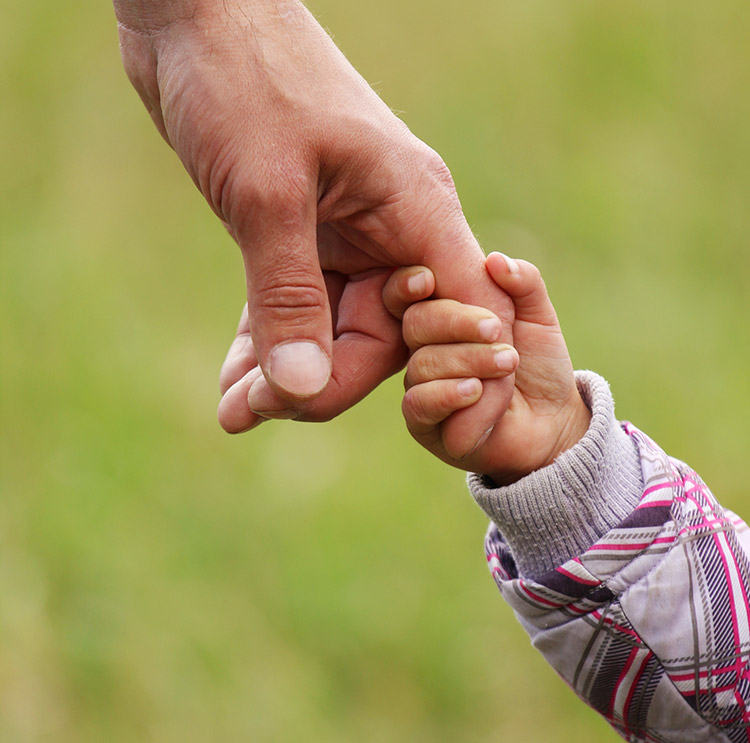 photo of a child holding his father's hand