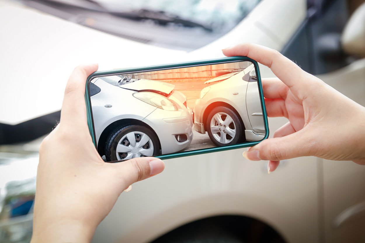 photo of a car accident victim taking photos of their vehicle after an accident