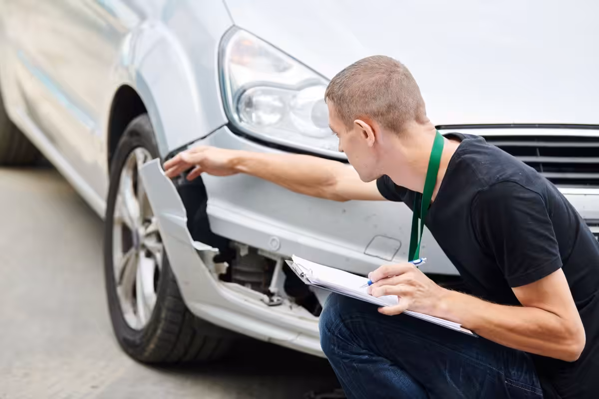 photo of a collision reporting technician examining the damage to a vehicle involved in a car accident in Edmonton