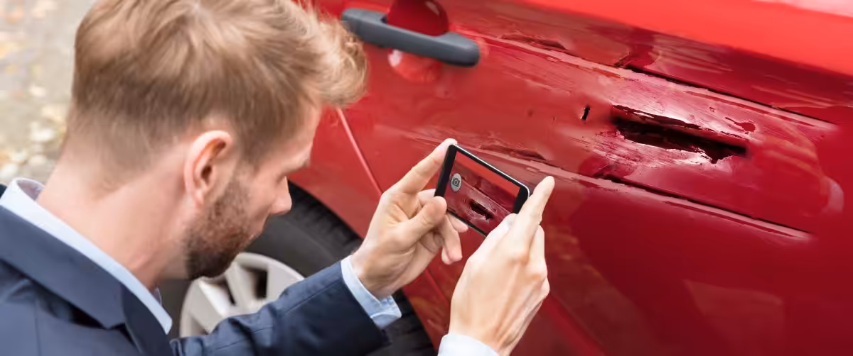 photo of a Collision Reporting Centre employee taking photos of a vehicle involved in a car accident