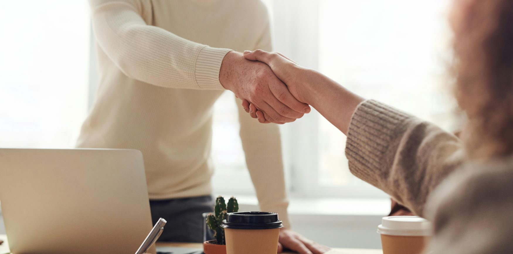 photo of a personal injury lawyer in Edmonton shaking hands with an injured client, discussing the contingency fee required to continue with their personal injury claim